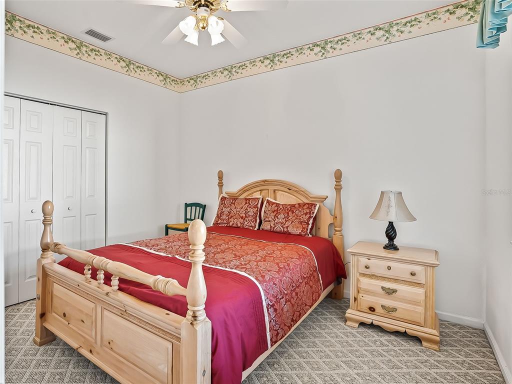 2323 Northwest 55th Avenue Road Ocala, FL 34482 - Photo 20 of 43 a bedroom with a bed and a chandelier