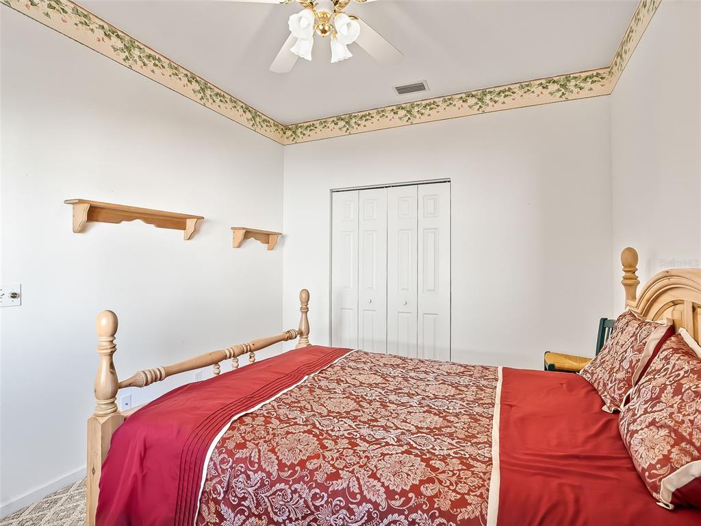 2323 Northwest 55th Avenue Road Ocala, FL 34482 - Photo 21 of 43 a bedroom with a bed and a chandelier