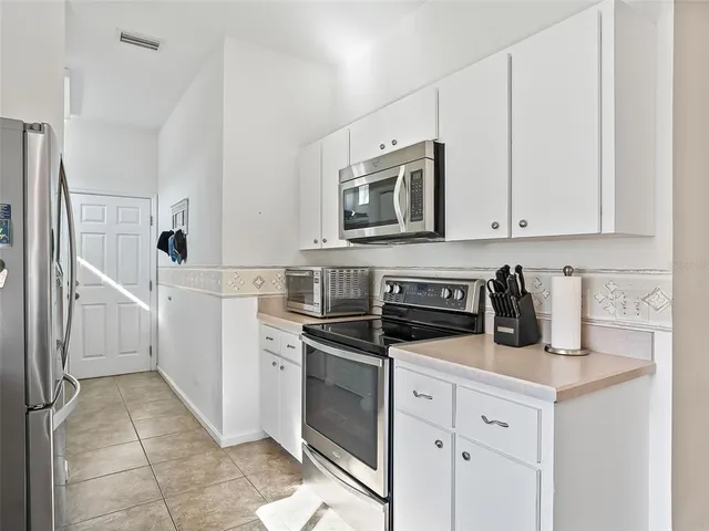 a kitchen with granite countertop white cabinets and white appliances
