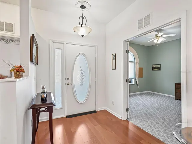 a view of a hallway with entryway wooden floor and front door