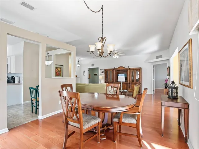 a dining room with furniture a chandelier and wooden floor