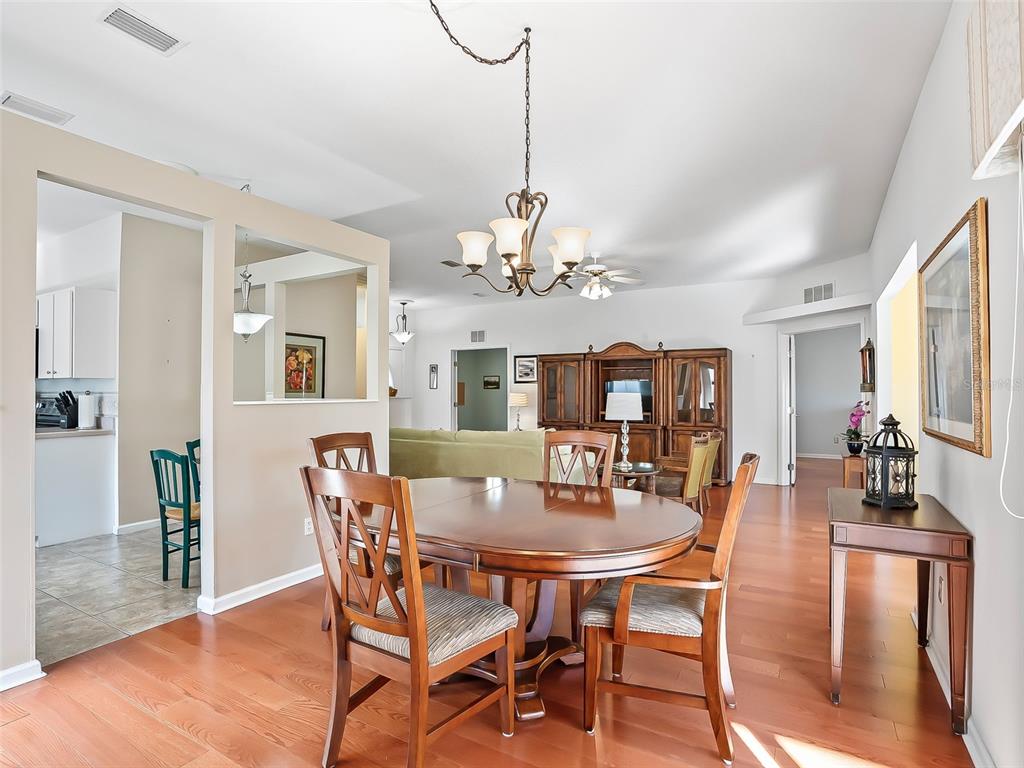 2323 Northwest 55th Avenue Road Ocala, FL 34482 - Photo 10 of 43 a dining room with furniture a chandelier and wooden floor