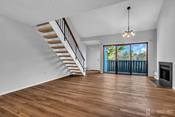 a view of a livingroom with wooden floor and a fireplace