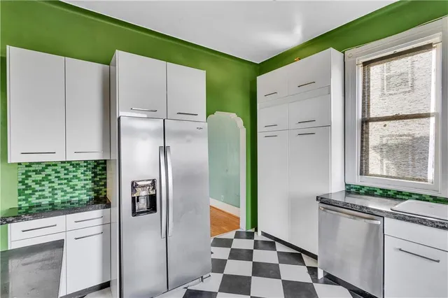 a kitchen with stainless steel appliances granite countertop a refrigerator and a stove