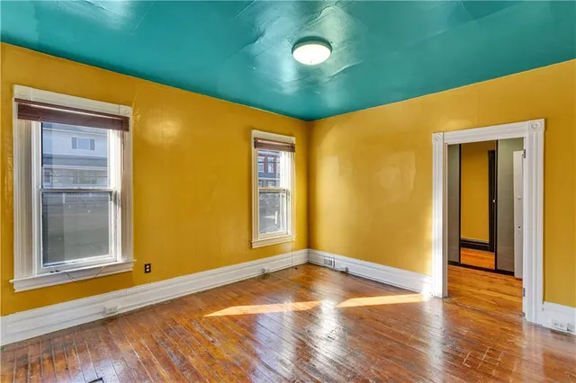 a view of a big room with wooden floor and windows