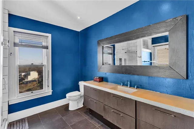 a bathroom with a toilet a sink and mirror