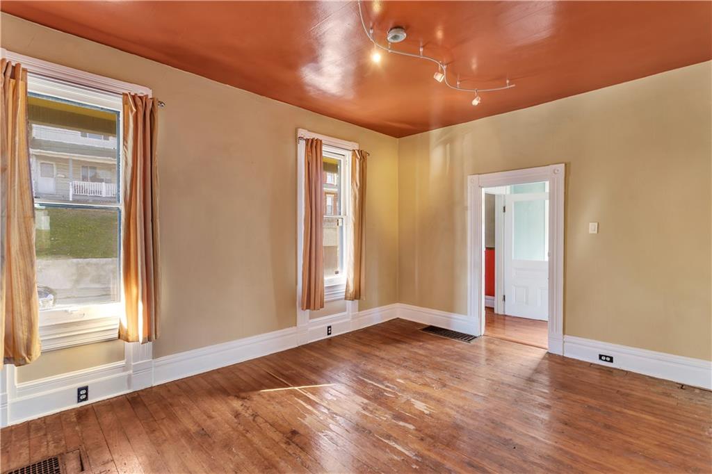 85 Wyoming Street Pittsburgh, PA 15211 - Photo 7 of 33 a view of an empty room with wooden floor and a window