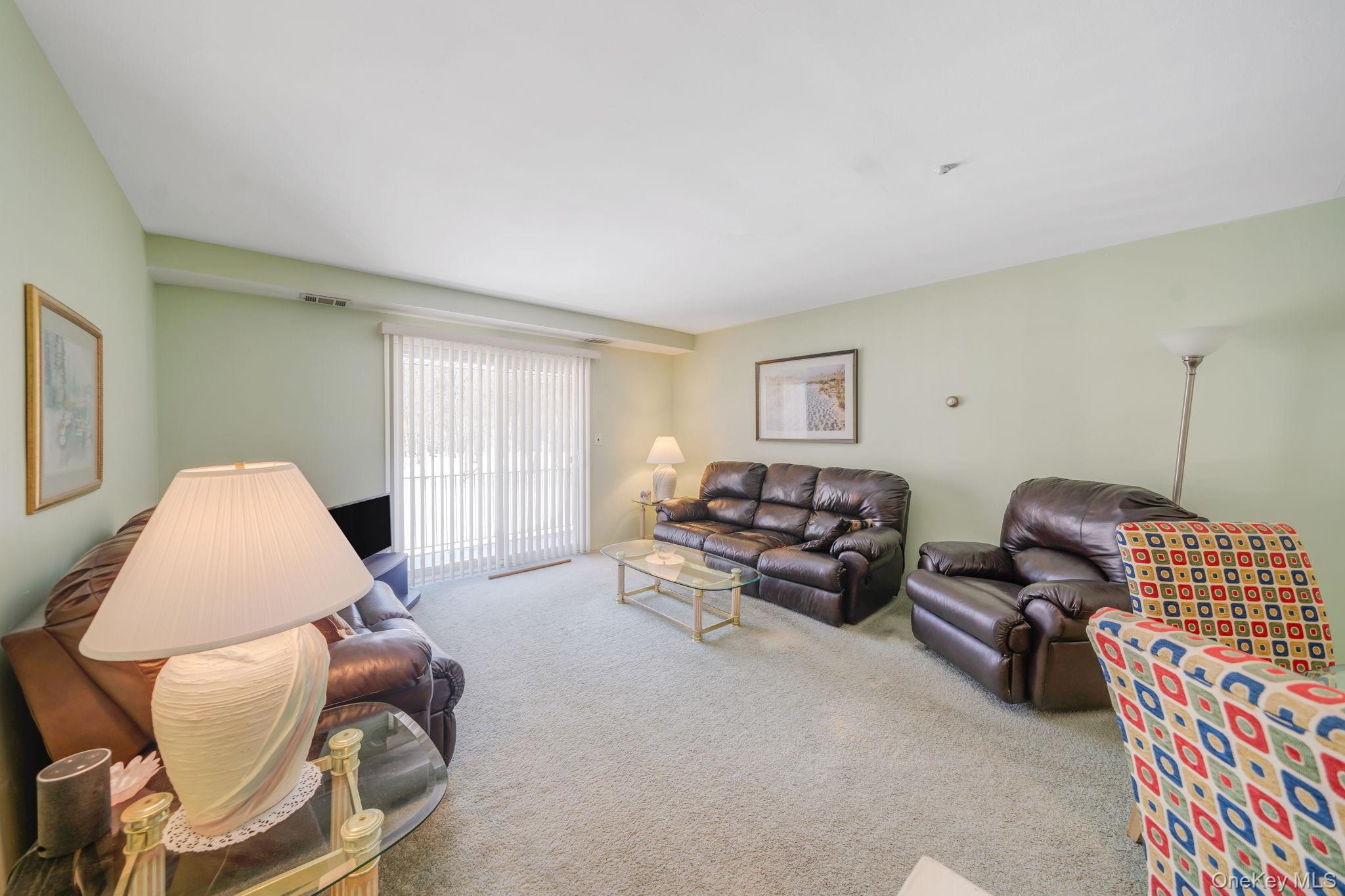 8 Juniper Court, Unit 8 Selden, NY 11784 - Photo 3 of 14 View of living room with balcony