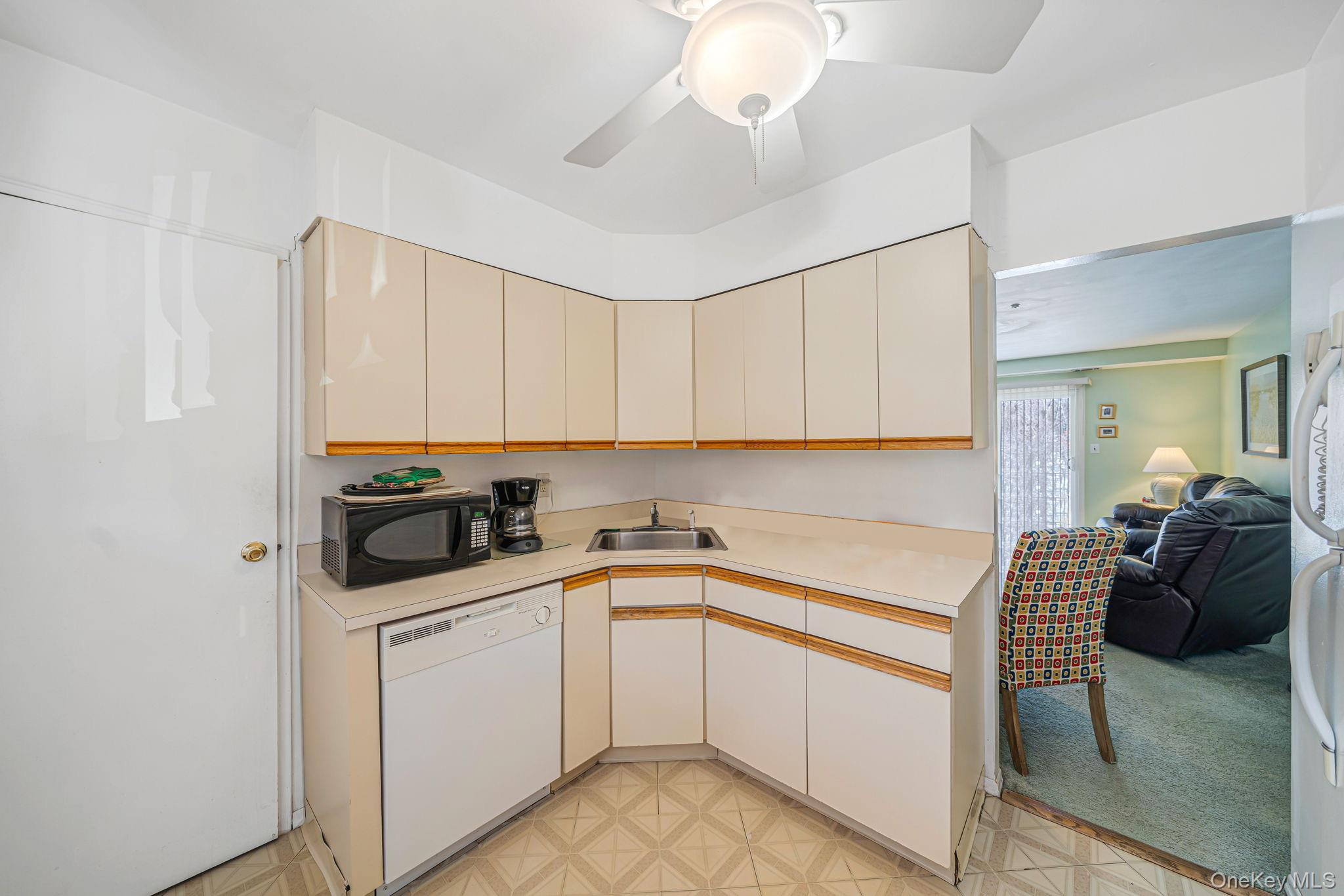 8 Juniper Court, Unit 8 Selden, NY 11784 - Photo 14 of 14 Kitchen featuring light floors, white appliances, light countertops, open floor plan, and ceiling fan