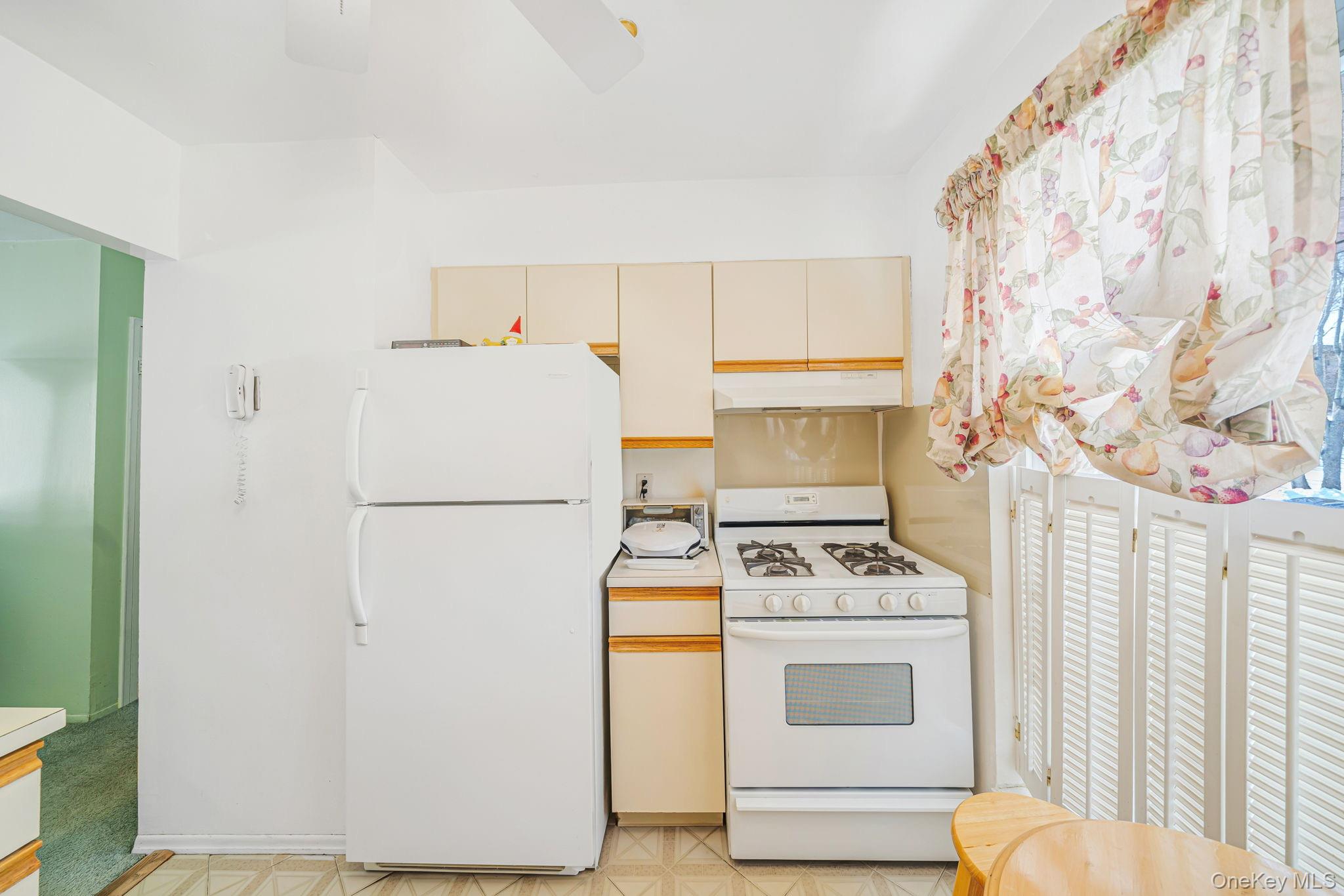 8 Juniper Court, Unit 8 Selden, NY 11784 - Photo 6 of 14 Kitchen featuring white appliances, light floors, light countertops, cream cabinetry, and a ceiling fan
