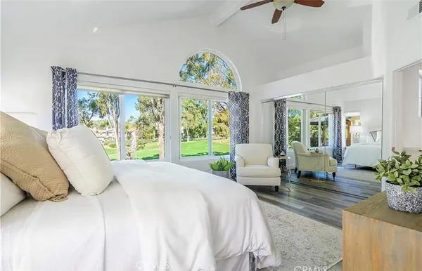 a bedroom with a bed and large windows