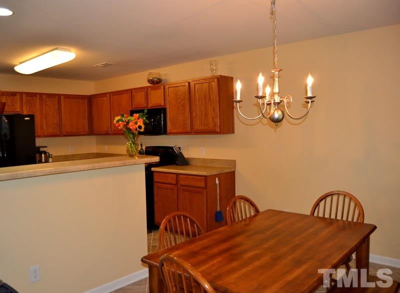 4235 Dalcross Road Raleigh, NC 27610 - Photo 11 of 25 a kitchen with stainless steel appliances a dining table and chairs