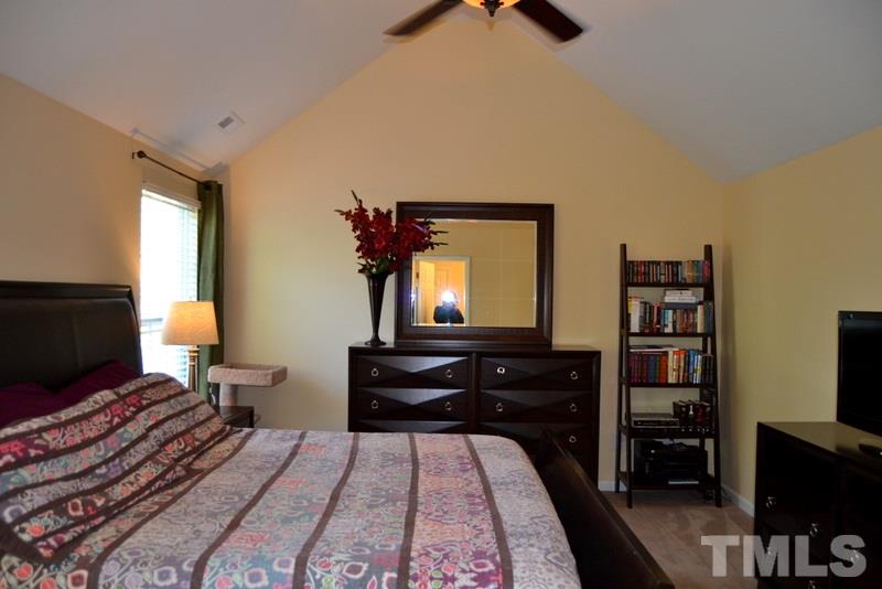 4235 Dalcross Road Raleigh, NC 27610 - Photo 14 of 25 a bedroom with a bed and a flat tv screen on a dresser