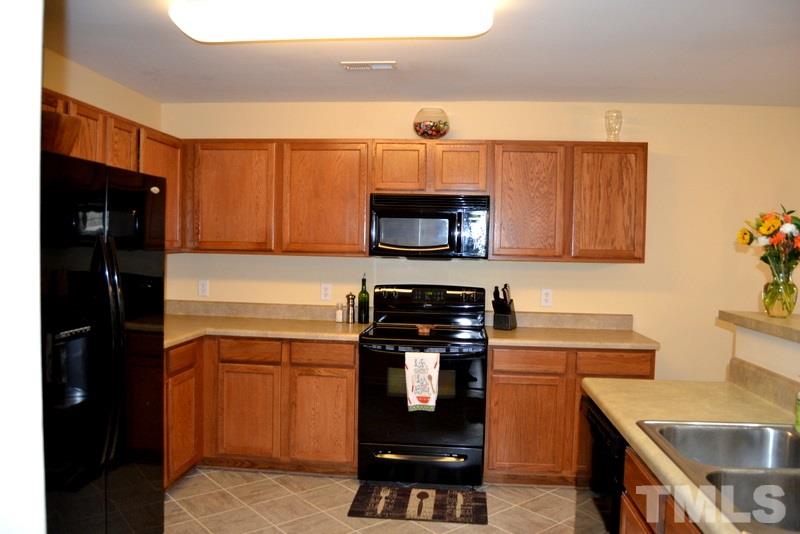4235 Dalcross Road Raleigh, NC 27610 - Photo 9 of 25 a kitchen with stainless steel appliances a stove microwave and refrigerator