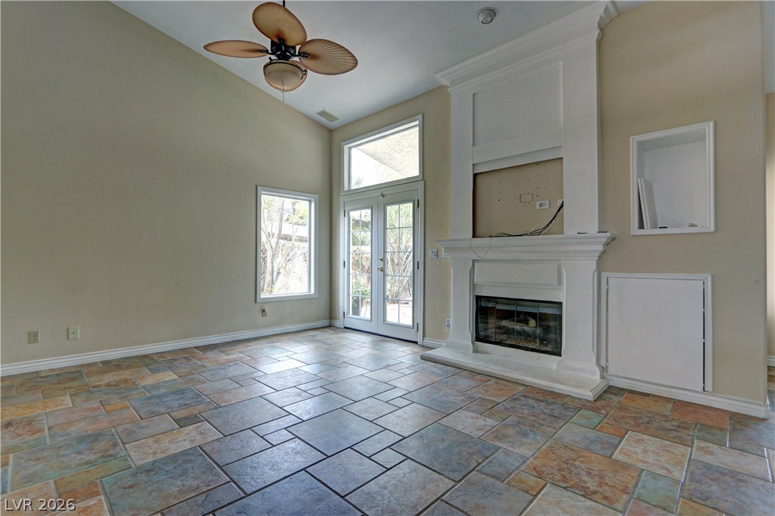 2108 Crestpoint Way Las Vegas, NV 89134 - Photo 7 of 27 Vast vaulted ceilings complement an inviting fireplace with French doors leading to exterior grounds.