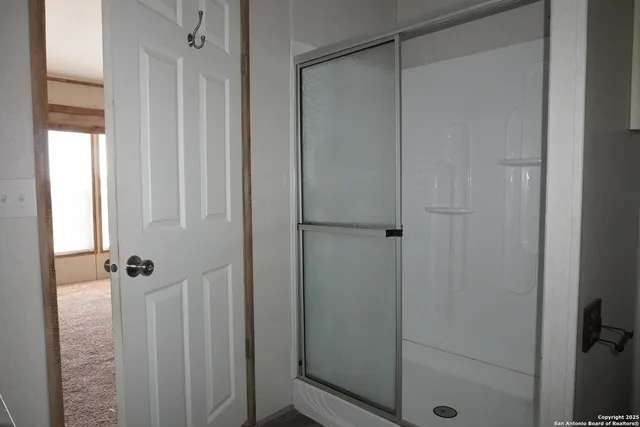 a bathroom with a glass shower door