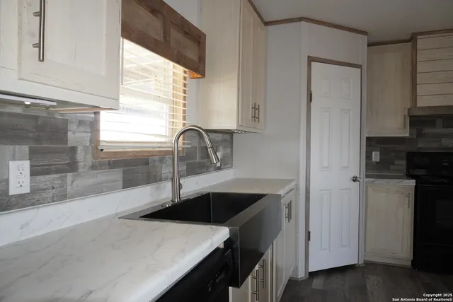 a kitchen with a sink a stove and cabinets