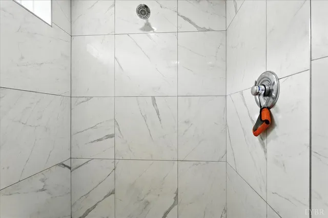 a living room with furniture a fireplace and a floor to ceiling window