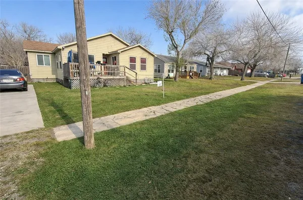 a front view of a house with a yard and trees