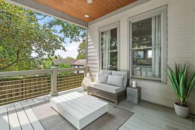 a view of a roof deck with couches and potted plants with wooden floor