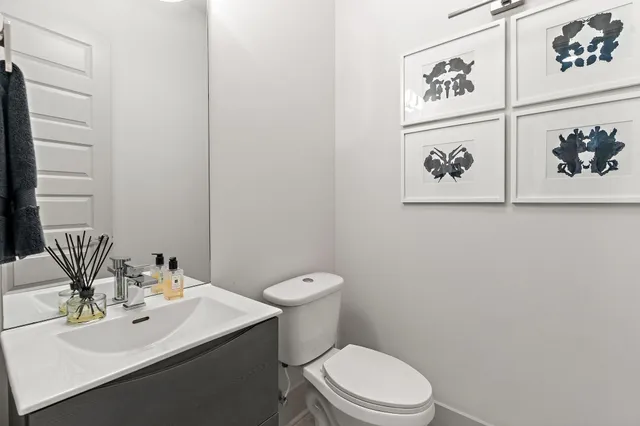 a bathroom with a toilet sink and mirror
