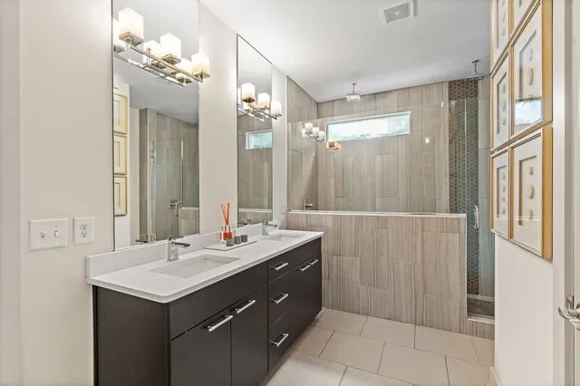 a bathroom with a double vanity sink mirror and shower