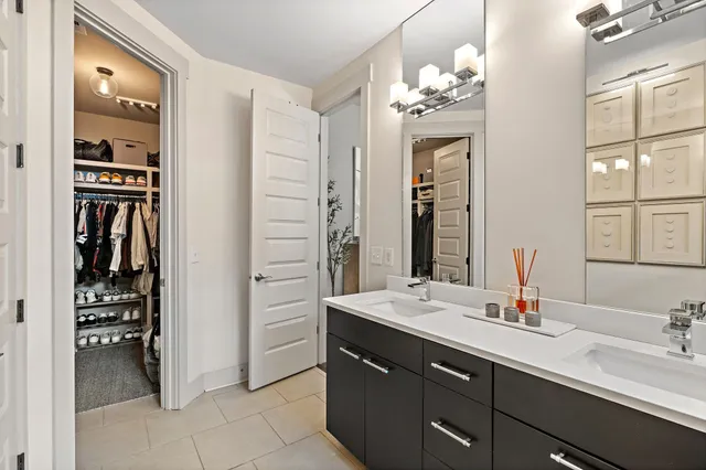 a bathroom with a double vanity sink a vanity and a large mirror