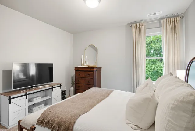 a bedroom with a bed and a flat screen tv