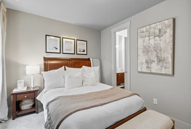 a bedroom with a large bed and a lamp on table