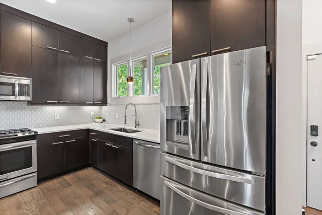 a kitchen with granite countertop stainless steel appliances and sink