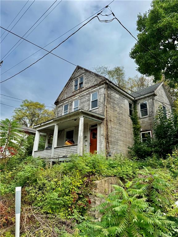 a front view of a house with a yard and potted plants
