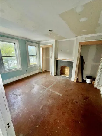 an empty room with fireplace and windows