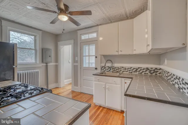 a kitchen with granite countertop a stove a sink and a refrigerator