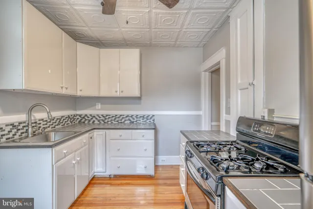 a kitchen with stainless steel appliances granite countertop a stove and a white cabinets