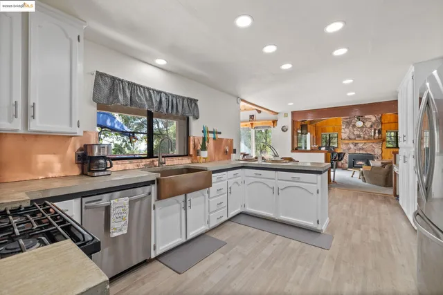 a kitchen with white cabinets and sink
