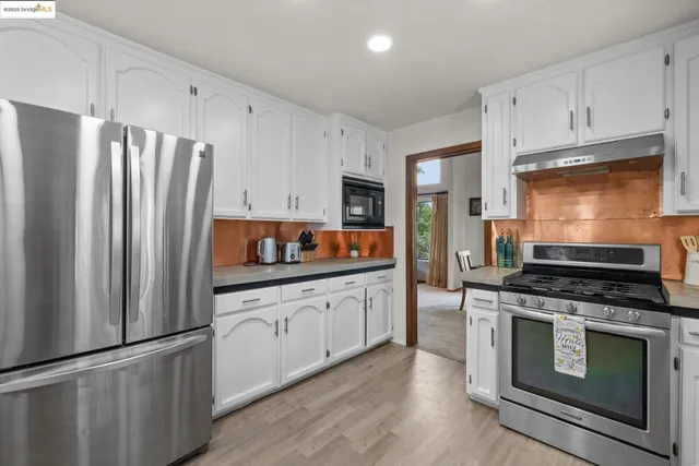 a kitchen with stainless steel appliances granite countertop a refrigerator stove and sink