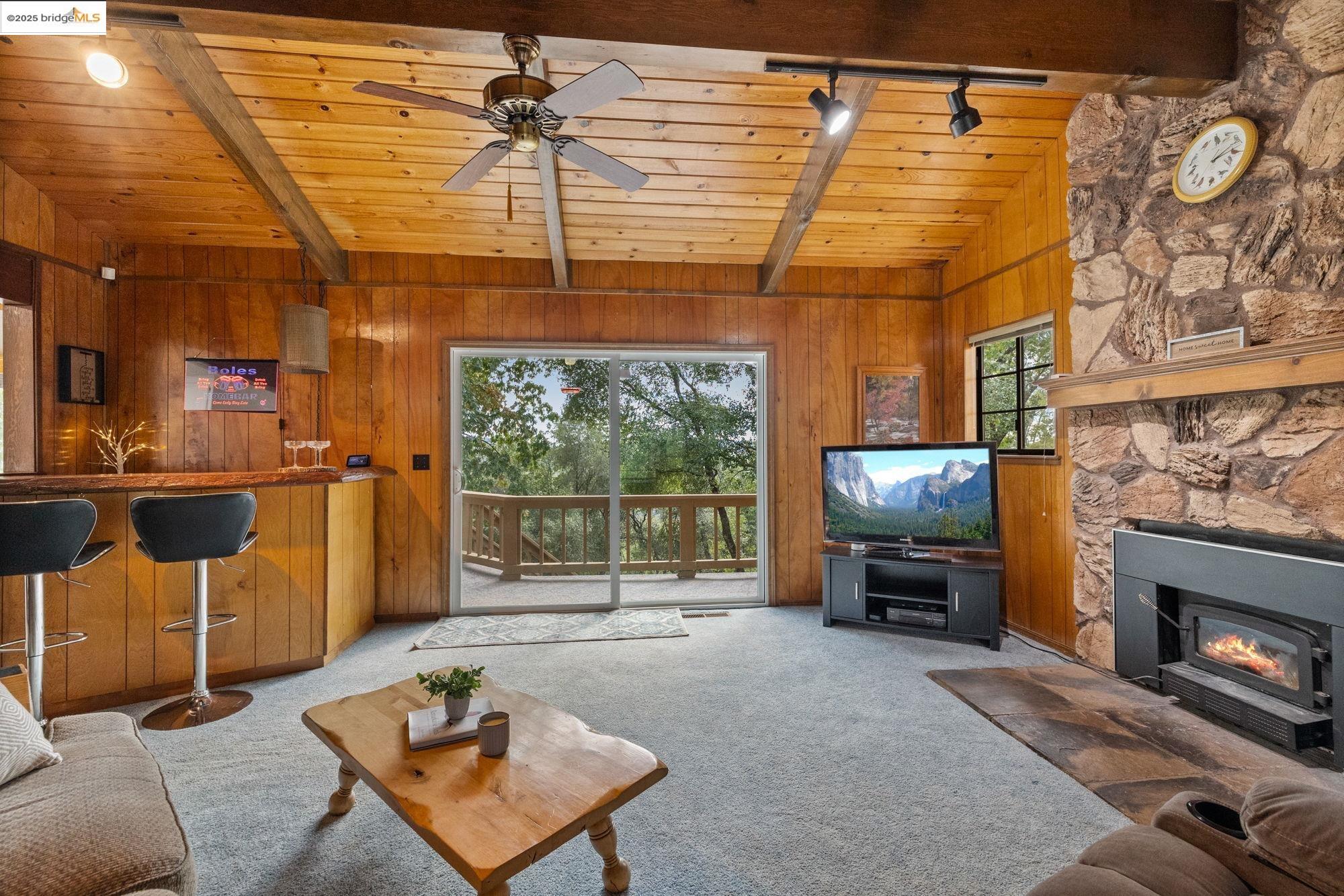 21950 Paseo De Los Portales Road Sonora, CA 95370 - Photo 20 of 47 a living room with furniture a flat screen tv and a fireplace