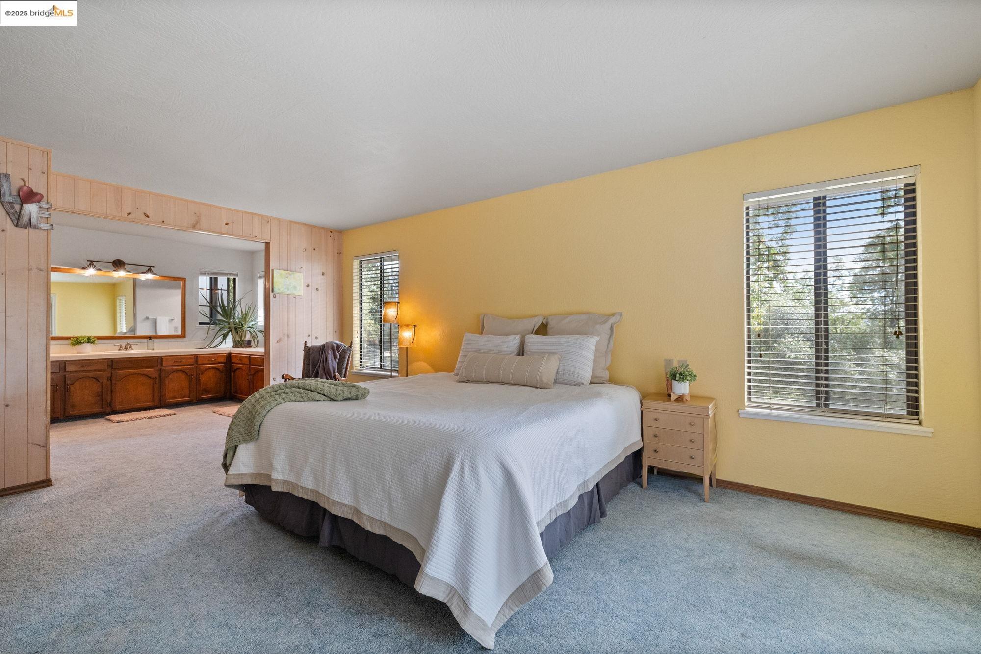 21950 Paseo De Los Portales Road Sonora, CA 95370 - Photo 28 of 47 a spacious bedroom with a bed and window