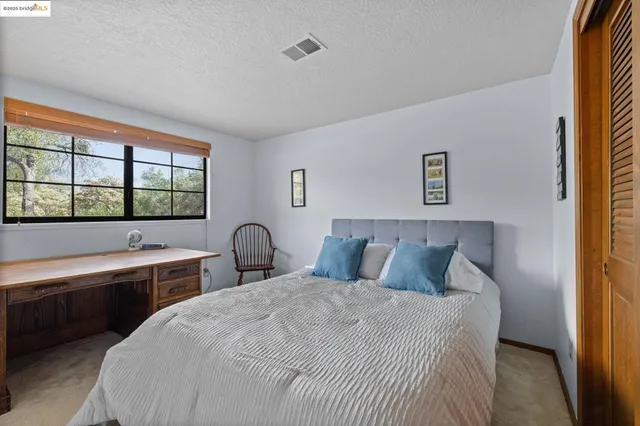 a bedroom with a bed and a large window