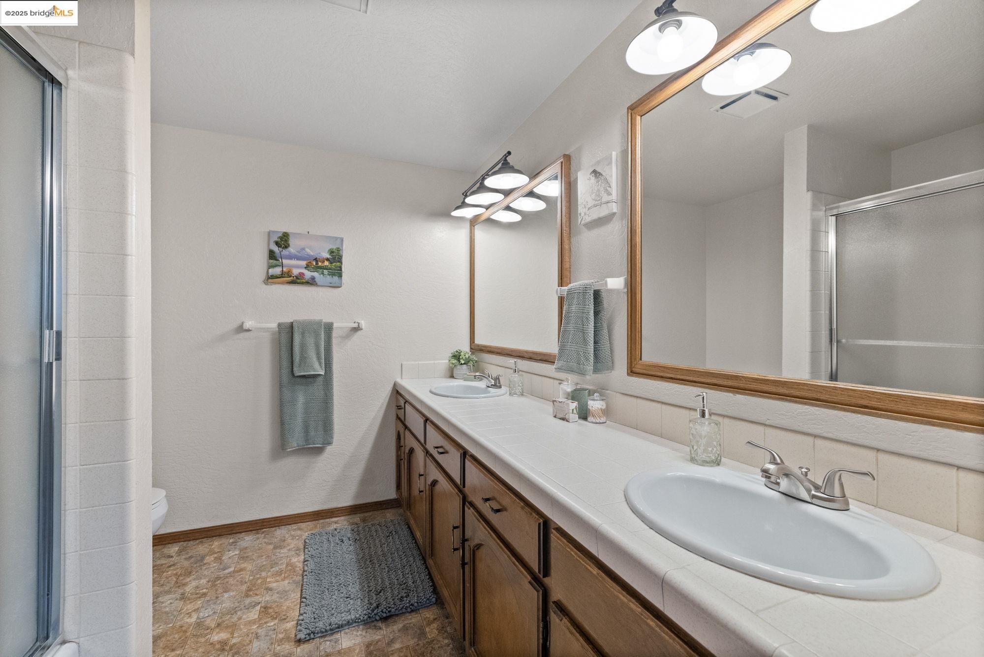 21950 Paseo De Los Portales Road Sonora, CA 95370 - Photo 34 of 47 a spacious bathroom with a double vanity sink a mirror and a shower