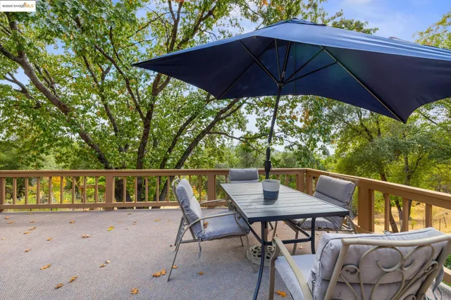 a patio with wooden floor table and chairs