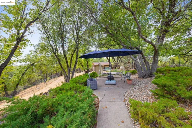 a view of a patio with table and chairs under an umbrella