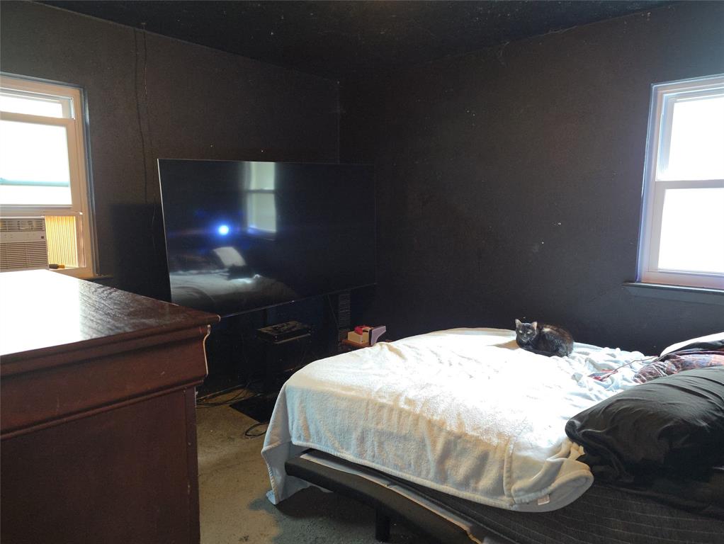 2908 East 15th Street Plano, TX 75074 - Photo 3 of 6 a bedroom with a bed and a chandelier