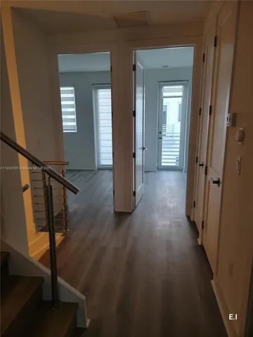 a view of a hallway with wooden floor and stairs