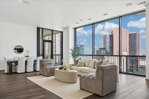 a living room with furniture kitchen view and large windows