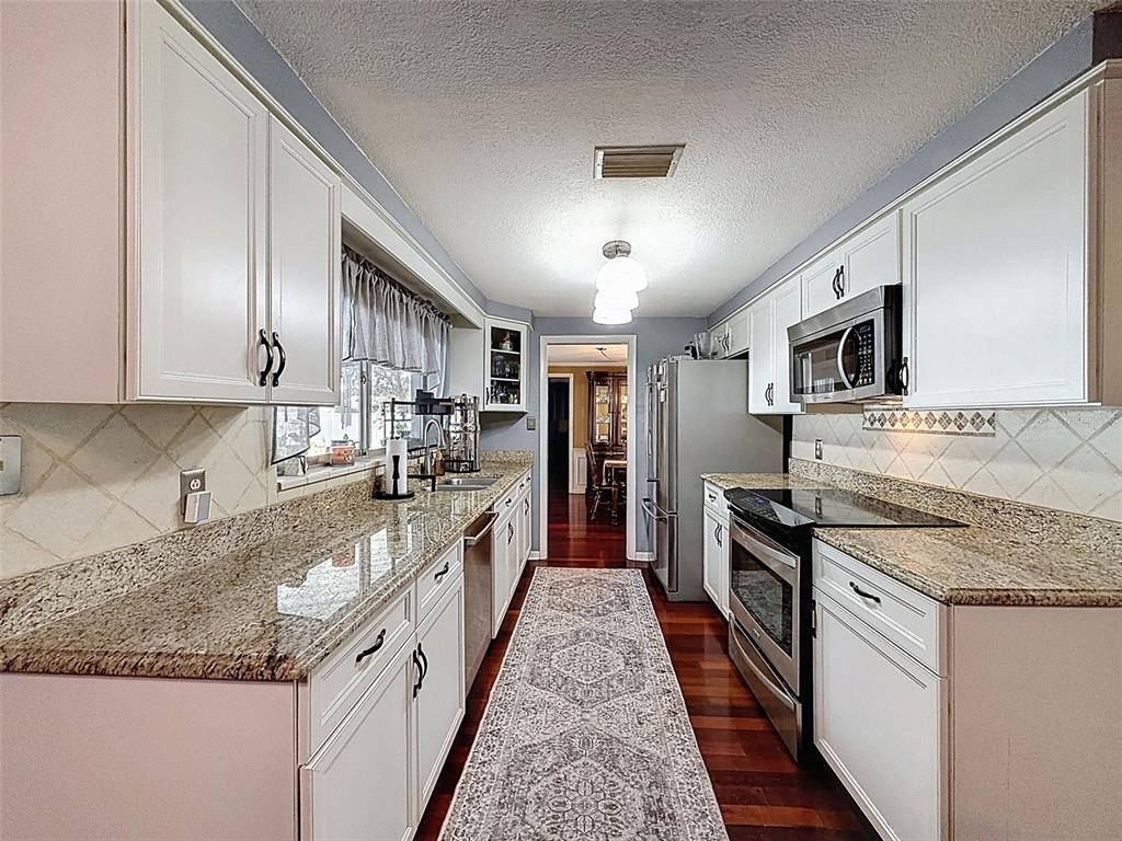 1602 Alder Way Brandon, FL 33510 - Photo 26 of 64 a large kitchen with stainless steel appliances granite countertop a stove refrigerator and a sink