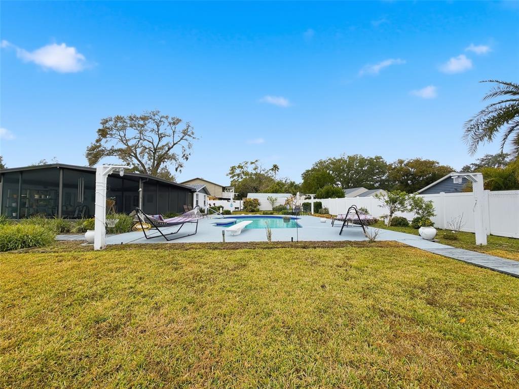 1602 Alder Way Brandon, FL 33510 - Photo 50 of 64 a view of a swimming pool with a lawn chairs under an umbrella