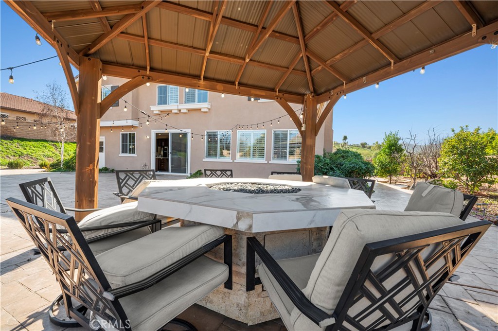 12810 Sierra Creek Drive Riverside, CA 92503 - Photo 13 of 52 a view of a patio with table and chairs under an umbrella