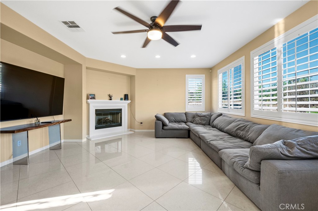12810 Sierra Creek Drive Riverside, CA 92503 - Photo 18 of 52 a living room with furniture a flat screen tv and a fireplace