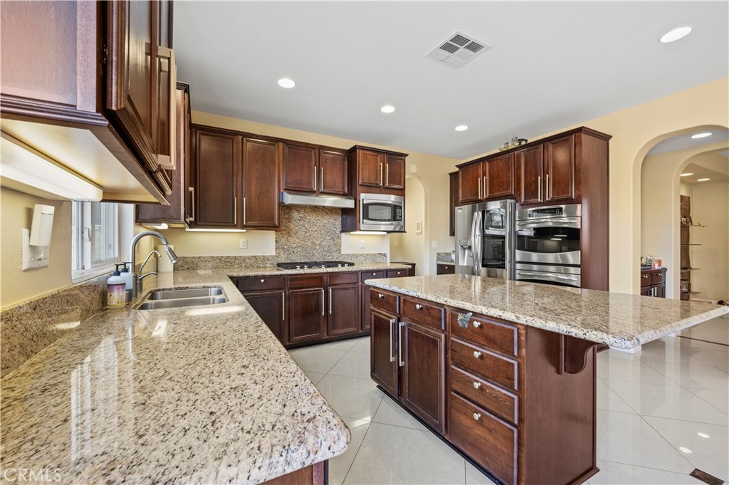 12810 Sierra Creek Drive Riverside, CA 92503 - Photo 23 of 52 a large kitchen with kitchen island a sink stainless steel appliances and cabinets